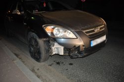 Samochód kia, którym potrącono dwóch mężczyzn z widocznymi uszkodzeniami zderzaka, opony i lusterka