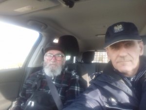 Dzielnicowy z Komisariatu Policji w Golinie siedzi w radiowozie wraz z 99-letniem mężczyzną, który przyszedł do komisariatu po pomoc, po zgubieniu w autobusie portfela.