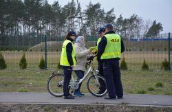 Policjanci z Komisariatu Policji w Sompolnie, Wydziału Prewencji, Wydziału Ruchu Drogowego wręczają rowerzystce elementy odblaskowe i oświetlenie rowerowe