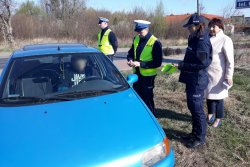 Policjanci z Komendy Miejskiej Policji w Koninie i przedstawicielka samorządu kontrolują pojazd i wręczają pamiątki