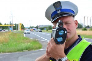 Policjant mierzący prędkość przy pomocy laserowego miernika