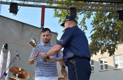 zastępcy komendanta miejskiego policji w Koninie wręczają puchary zwycięzcom biegu
