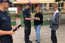 Policjanci rozmwiają z uczniami przed szkołą