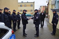 Policjanci odbierają od samorządowców oznakowany radiowóz