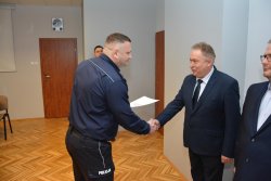 Zastępca Komendanta Miejskiego Policji w Koninie wręcza pisemne podziękowania policjantowi odchodzącemu na emeryturę
