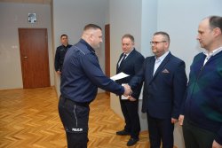 Zastępca Komendanta Miejskiego Policji w Koninie wręcza pisemne podziękowania policjantowi odchodzącemu na emeryturę