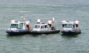 Trzy motorówki policyjne nad wodą