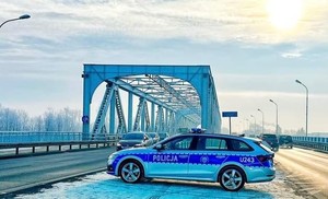 Radiowóz na tle &quot;Mostu Żelaznego&quot; w Koninie na ul. Warszawskiej